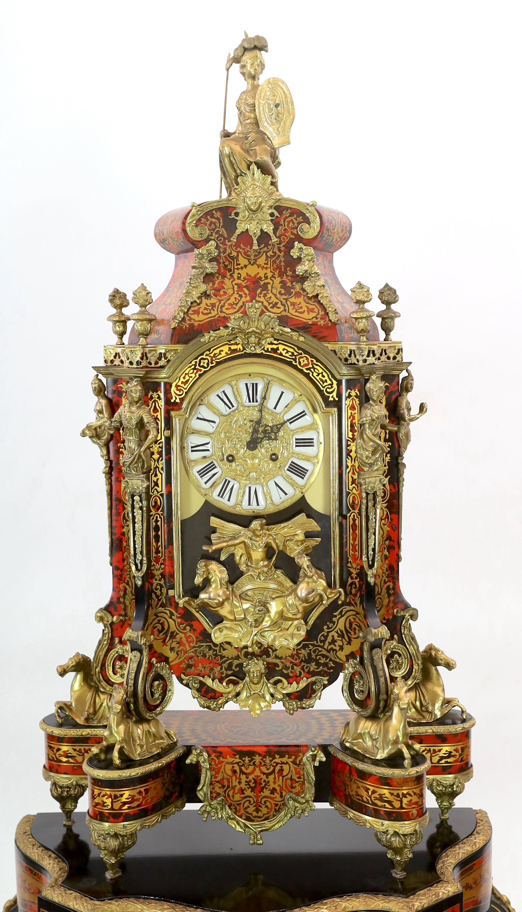 A Louis XV style brass mounted red boulle mantel clock on matching stand